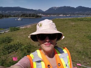 Biologist in high visibility vest on a large green roof