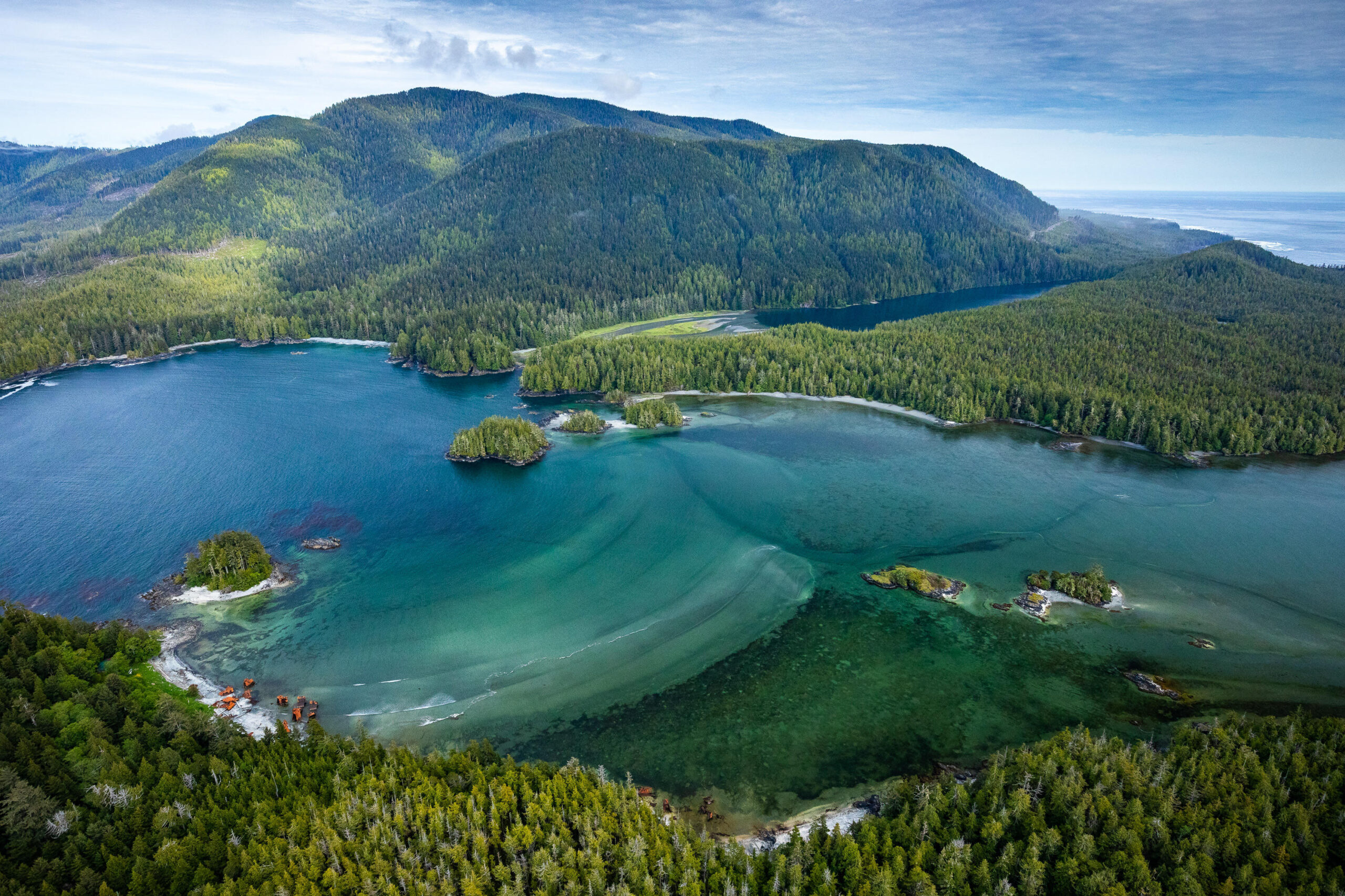 Forested mountains around an inlet of blue water